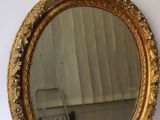 un miroir accroché au mur à côté d'une chaise