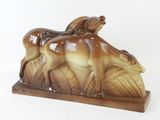 une figurine représentant un cheval et un chien, posée sur un socle en bois