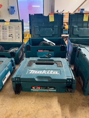 Plusieurs outils Makita sont posés par terre dans une pièce
