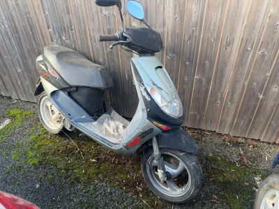 un scooter garé à côté d'une clôture en bois