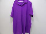a purple polo shirt hanging on a hanger on a wall