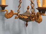 a chandelier with three candles hanging from it