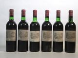 six bottles of wine are lined up on a white surface