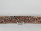 une sculpture en bois représentant un groupe de personnes sur fond rouge