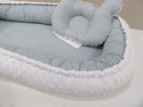 a baby elephant laying in a bed on a table
