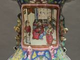 a vase with a painting on it sitting on a table