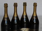 four bottles of champagne are lined up on a table