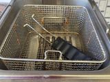a deep fryer that has two tongs in it
