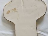 a white ceramic cross with blue writing on it