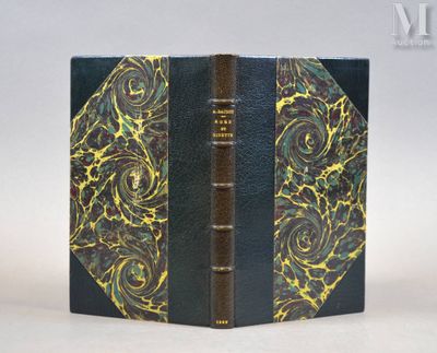 un vieux livre à la couverture dorée et noire posé sur une table