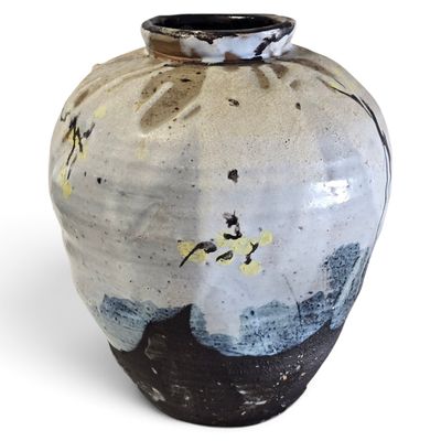 a black and white vase sitting on a white surface