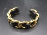 un gros plan d'un bracelet doré et noir posé sur une table