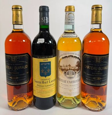 four bottles of wine are lined up on a white surface