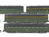 six green train cars sitting next to each other on a white surface
