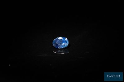 a blue sapphire stone on a black surface