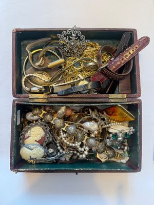 a box full of gold and silver jewelry on a table