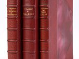 trois livres rouges superposés sur une surface blanche