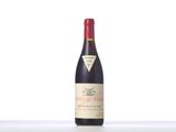 a bottle of red wine sitting on top of a white table