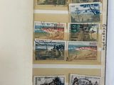 an open book with stamps on it on a white surface