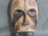 a wooden mask on a table with a blue cloth