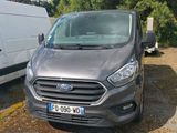 une camionnette grise garée à côté d'une camionnette blanche sur un parking
