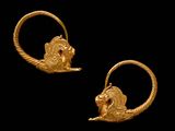 une paire de boucles d'oreilles créoles en or ornées d'une tête de lion
