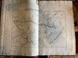 an old book with a map on it sitting on a table