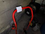 a red handlebar with a sticker on it next to a fire hydrant