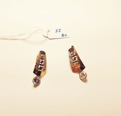 two pieces of jewelry on a white surface with a price tag