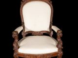 an old chair with a white upholstered seat and a wooden frame