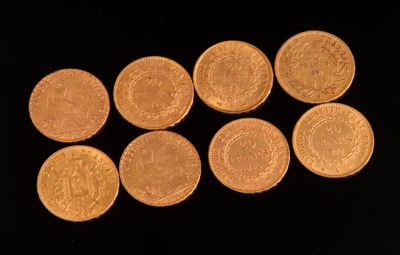 six pièces d'or sont disposées en ligne sur une surface noire