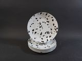 a stack of four plates with black spots on them