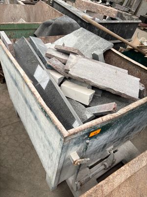 a large pile of granite blocks in a metal container