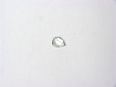 un gros plan d'un objet en argent posé sur une surface blanche