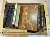 de nombreux livres dans une boîte en bois posée sur une table