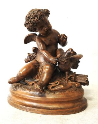 a small statue of a boy with a bird on a pedestal