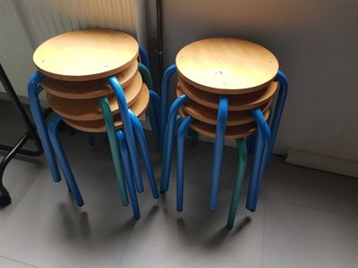 four wooden stools sitting next to each other on the floor