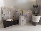 une étagère blanche sur laquelle se trouvent une lampe, une boîte et d'autres objets