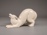 une sculpture blanche représentant un lapin posée sur une surface grise