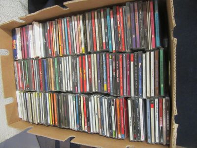 a cardboard box filled with many different cd ' s
