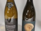 two bottles of wine sitting next to each other on a table