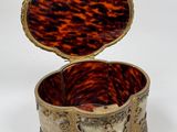 a small tortoise shell box on a white surface