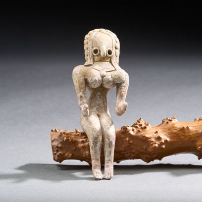 une image représentant une statue d'une femme assise sur une branche d'arbre