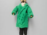 stuffed animal dressed in green coat and black pants on grey background