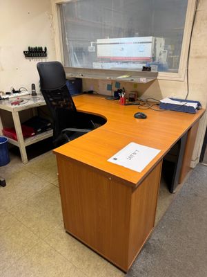 un bureau avec un écran d'ordinateur et une chaise dans un coin