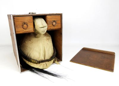 une petite boîte en bois contenant une poupée