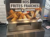 une enseigne sur laquelle on peut lire « frites frites frites frites, fabriquées en Normandie »
