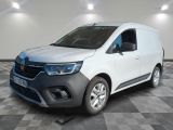 La camionnette blanche est garée dans une pièce au sol carrelé en damier.
