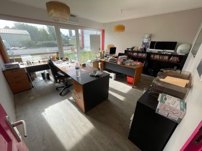 une salle avec de nombreux bureaux et une grande fenêtre