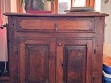 a wooden cabinet with a potted plant on top of it